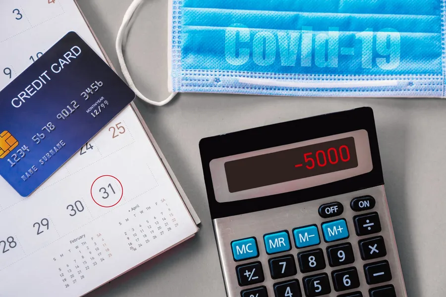 A credit card sitting on top of a calendar beside a calculator