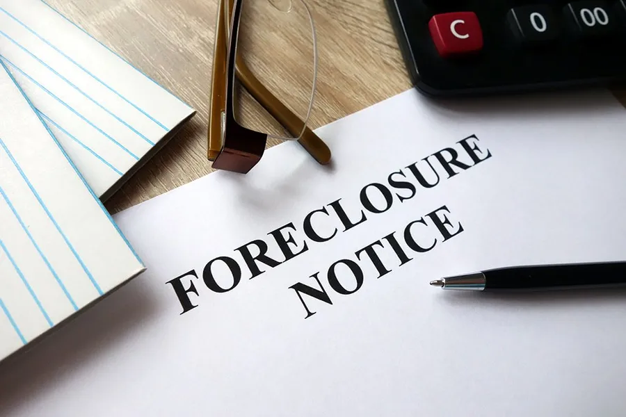A "Foreclosure Notice" sitting on a desk