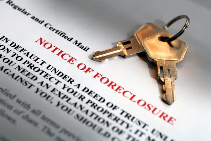 Two brass house keys rest atop a "Notice of Foreclosure" document, received via certified mail.