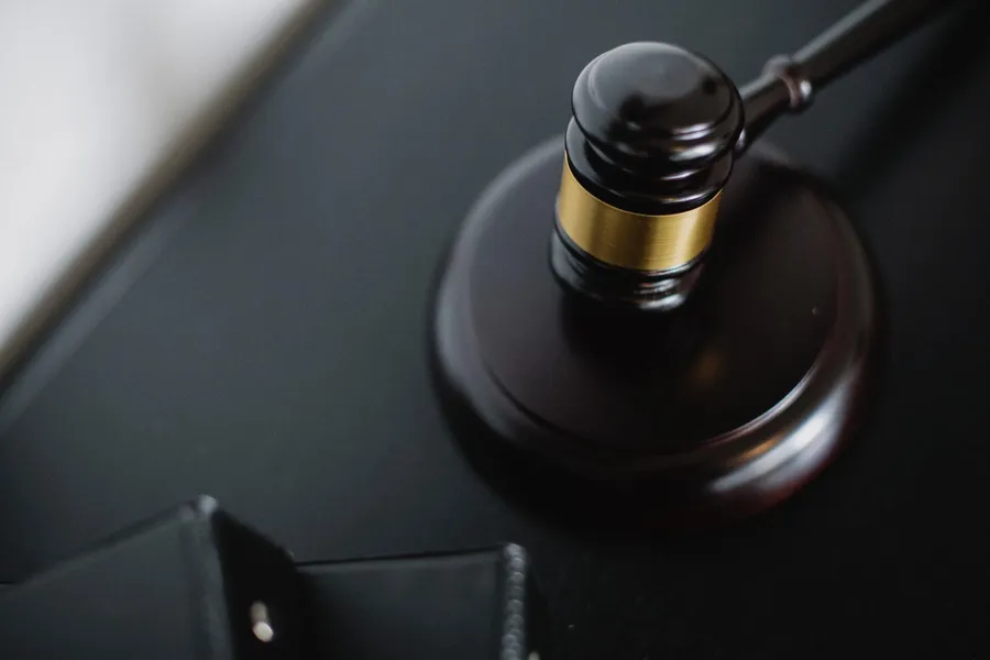 Wooden judge's gavel on a desk with a blurry background.