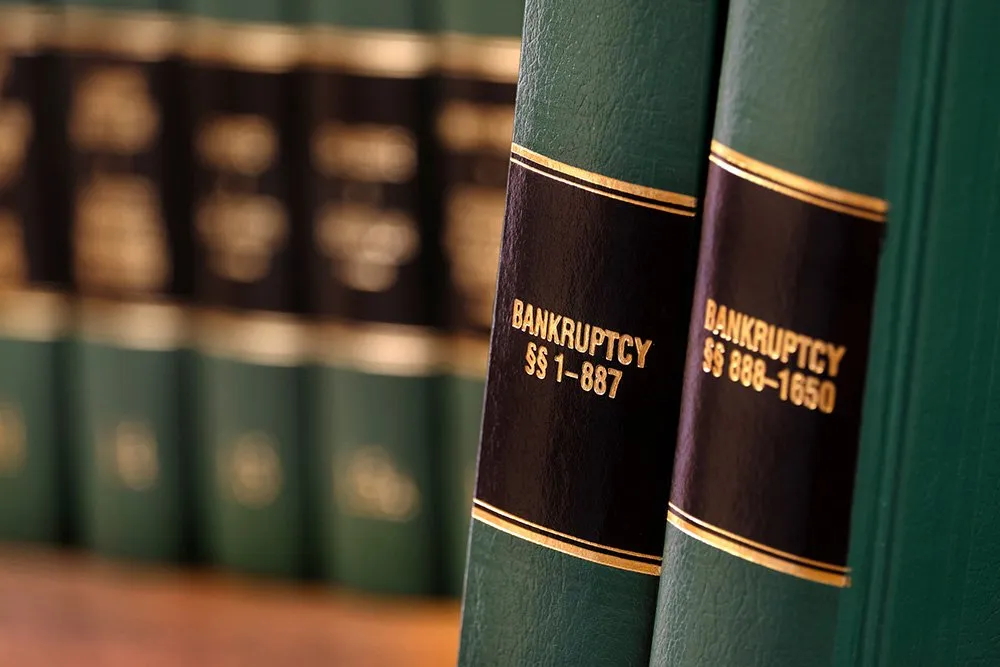 Close-up of a row of green legal books with black and gold labels, focusing on titles like "Bankruptcy §§ 1-887" and "Bankruptcy §§ 888-1650," essential for understanding chapters 7 and 13 bankruptcy.