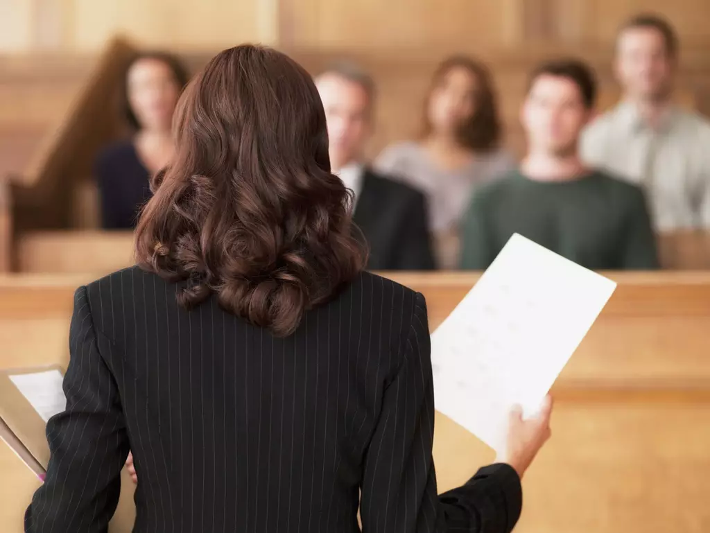 Attorney in a courtroom holding a lawsuit in the air