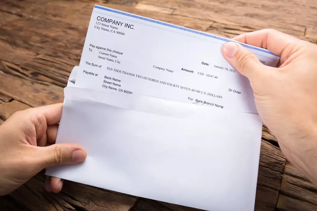 Paycheck sticking out of an envelope